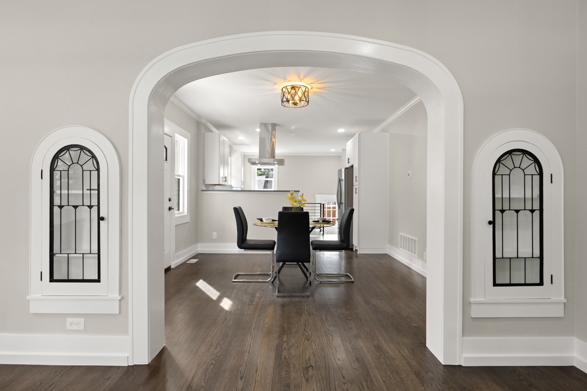 a dining room with a table and chairs in it related to Valances for Arched Windows: Enhancing Your Home's Aesthetic