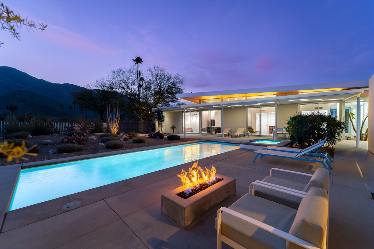 a fire pit sitting next to a swimming pool related to Ignite the Night with La Hacienda's Timeless Cast Iron Chiminea