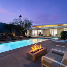 a fire pit sitting next to a swimming pool related to Ignite the Night with La Hacienda's Timeless Cast Iron Chiminea