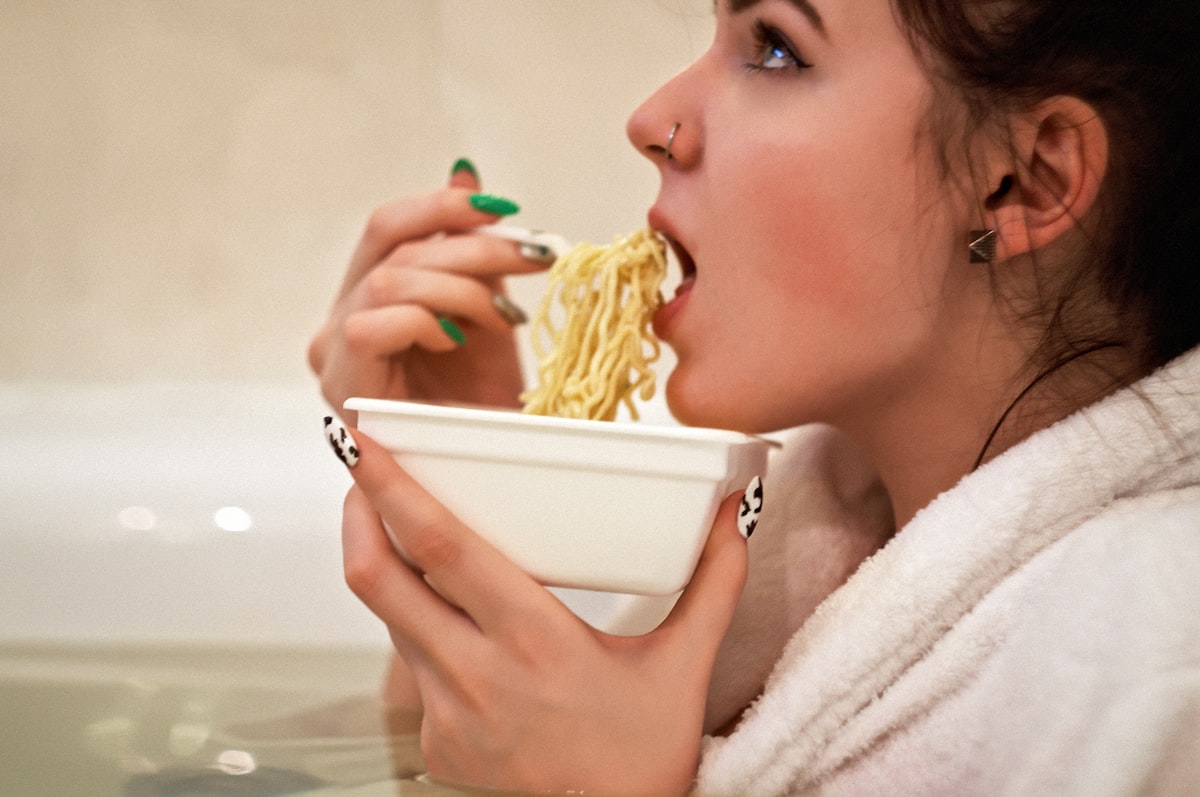 A girl eating instant noodles in a jacuzzi wearing a bathrobe related to Weighing Your Options: The Bed Bath & Beyond Food Scale