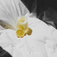 a glass of lemonade sitting on top of a bed related to The Ultimate Guide to Juicers at Bed Bath & Beyond: Everything You Need to Know
