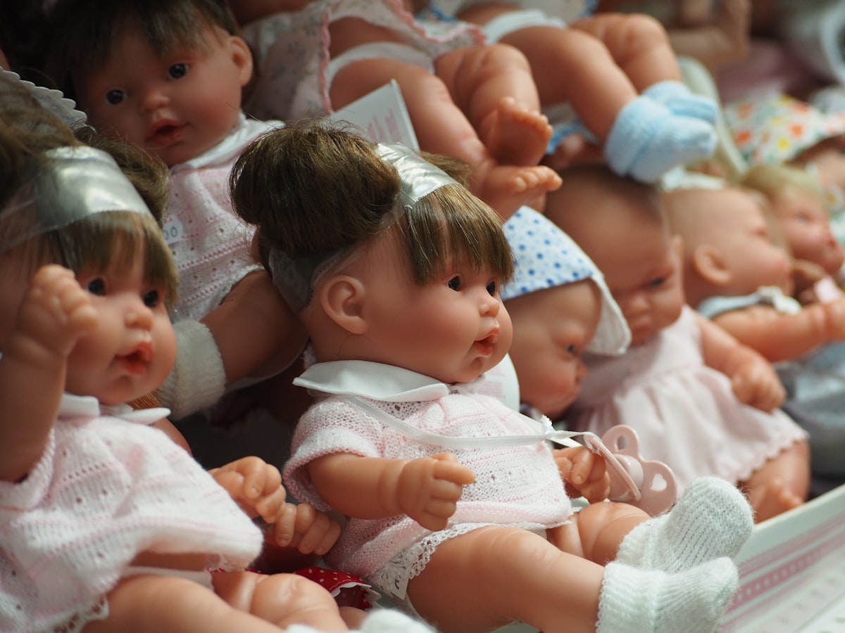 a group of baby dolls sitting next to each other related to The Ultimate Guide to Baby Beds for Dolls: Choosing the Perfect Miniature Crib
