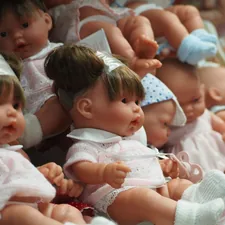 a group of baby dolls sitting next to each other related to The Ultimate Guide to Baby Beds for Dolls: Choosing the Perfect Miniature Crib