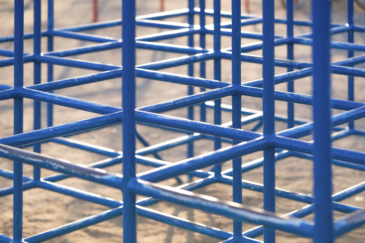 A group of blue metal structures sitting on top of a dirt field related to Exploring the Charm and Functionality of Blue Bunk Beds