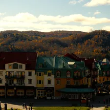 a group of buildings with a mountain in the background related to Charming Stays in Quebec City