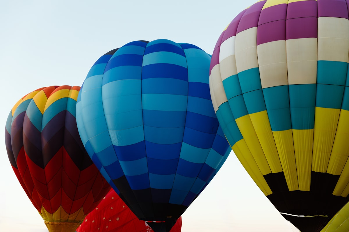 A group of colorful hot air balloons flying in the sky related to Elevate Your Nursery with Hot Air Balloon Baby Bedding