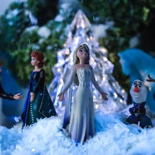 a group of figurines standing in front of a christmas tree related to Chilling Style: The Ultimate Guide to Frozen Crib Bedding