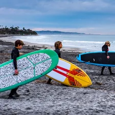 a group of people carrying surfboards on a beach related to Maximizing Storage with Style