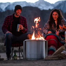 a group of people sitting around a fire pit related to The Ultimate Guide to Truck Bed Camping