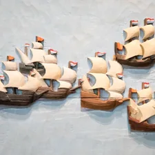 a group of wooden boats on display on a wall related to Why Pirate Ship Beds Are Every Kid's Dream Bedroom Addition