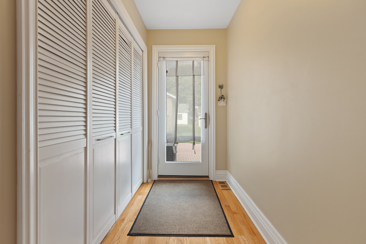 a hallway with a door and a rug on the floor related to Maximizing Space in Your Home with Entryway Storage Cabinets