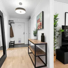A hallway with a mirror and a television on a stand related to Elevate Your Home's First Impression: Entryway Hall Tree with Storage