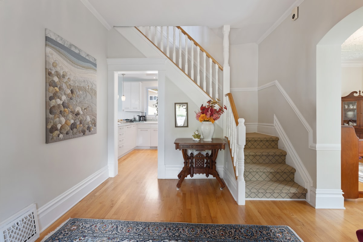 a hallway with a wooden floor and a painting on the wall related to Transform Your Entryway with the Perfect Storage Bench