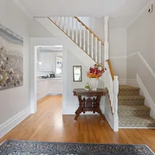a hallway with a wooden floor and a painting on the wall related to Transform Your Entryway with the Perfect Storage Bench