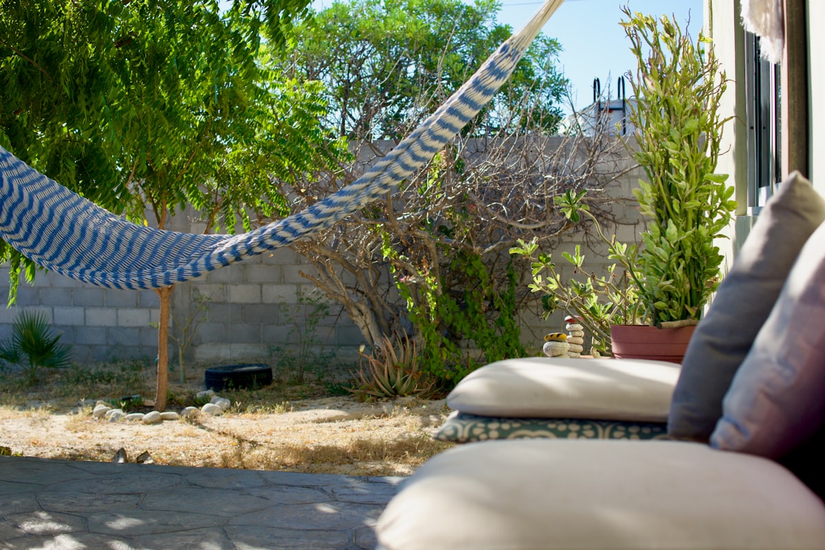 A hammock hangs in a sunny backyard with outdoor seating. related to Protect Your Outdoor Oasis: Essential Extra Large Chiminea Cover