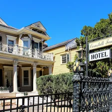 a hotel sign is posted on a wrought iron fence related to Exploring New Orleans: The Charm of Bed and Breakfasts in the French Quarter