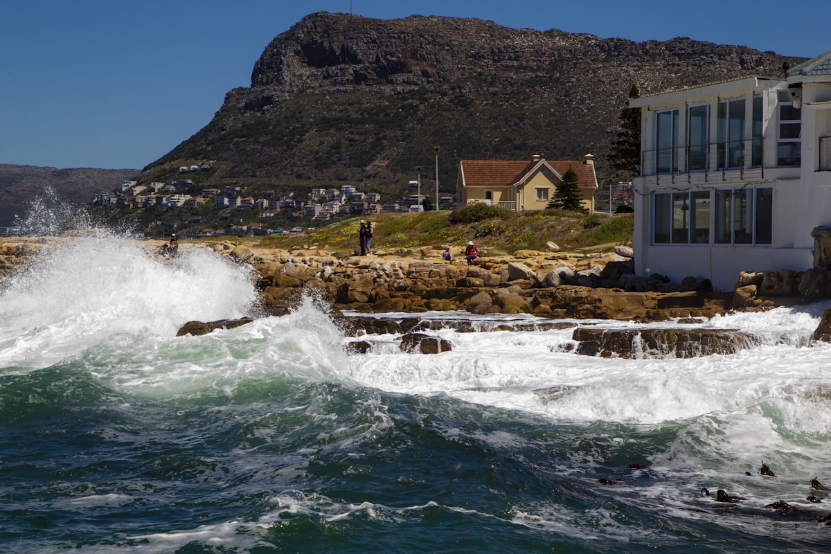 a house on the shore with waves crashing in front of it related to Charming Stays in Cape Cod