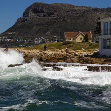 a house on the shore with waves crashing in front of it related to Charming Stays in Cape Cod