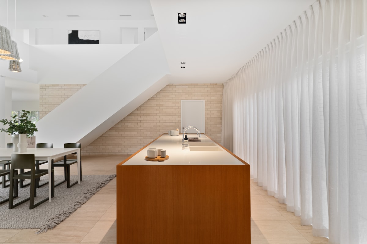 A kitchen and dining room with a staircase in the background related to Kitchen Curtain Valances: Elevate Your Kitchen Decor