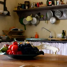 a kitchen with a table and a sink with food on it related to French Country Kitchen Valances: Elegance and Charm for Your Space