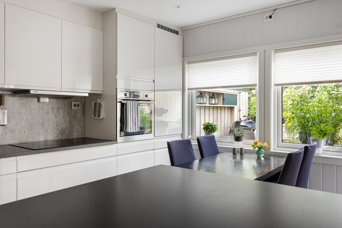 A kitchen with a table and chairs next to a window related to Black Kitchen Curtains and Valances