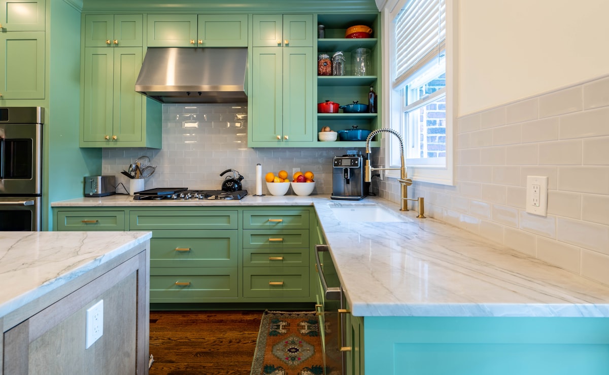 a kitchen with green cabinets and marble counter tops related to Elevate Your Kitchen Design with Black Kitchen Valances