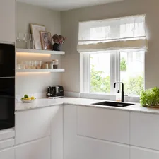 A kitchen with white cabinets and a black oven related to 10 Creative Kitchen Swags and Valances to Brighten Up Your Space