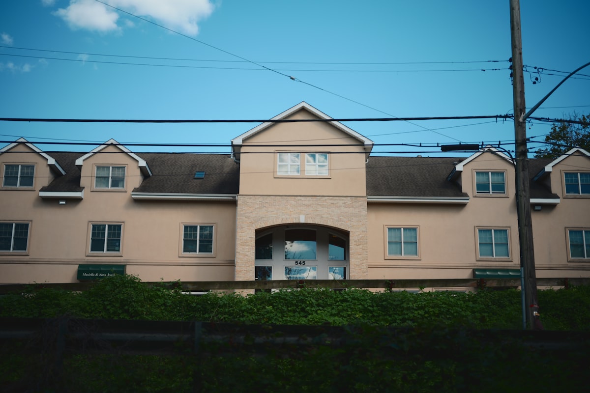 A large beige building with dormers under a blue sky. related to Inspiring Front Entryway Design Ideas