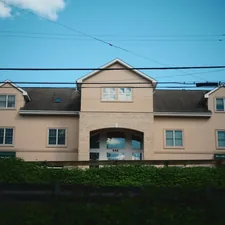 A large beige building with dormers under a blue sky. related to Inspiring Front Entryway Design Ideas