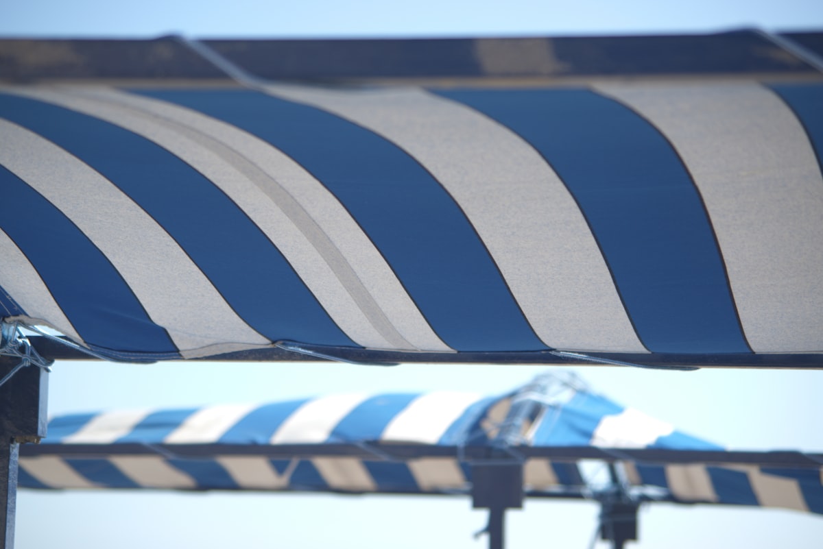 a large blue and white striped umbrella on a sunny day related to Striped Valances for Windows: Elegance and Style Redefined