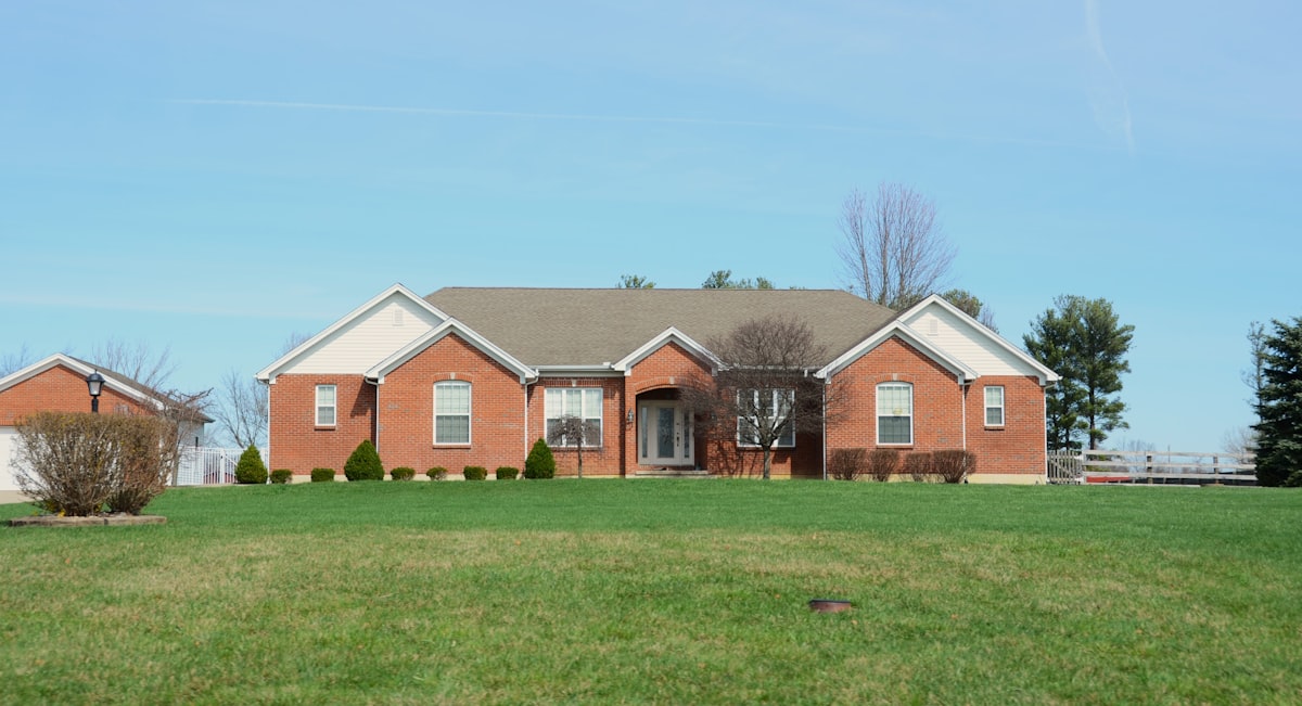 A large brick house with a manicured lawn. related to Spacious 3-Bedroom, 2-Bathroom Rental Home