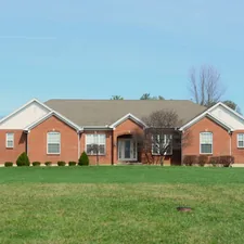 A large brick house with a manicured lawn. related to Spacious 3-Bedroom, 2-Bathroom Rental Home
