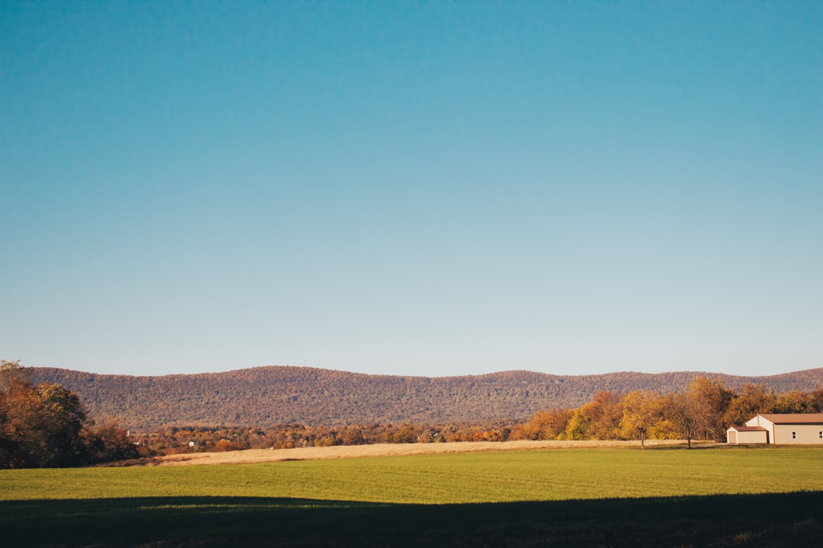 a large green field with a house in the distance related to Bringing the Charm of the Country Side to Your Home: Country Style Curtains and Valances