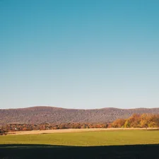 a large green field with a house in the distance related to Bringing the Charm of the Country Side to Your Home: Country Style Curtains and Valances