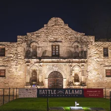 a large stone building with a sign in front of it related to Experience the Charm of San Antonio Bed and Breakfast