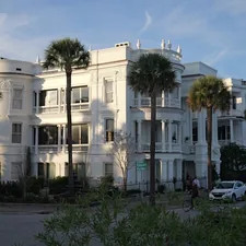 A large white building with palm trees in front of it related to Exploring Bed Bath and Beyond in Charleston