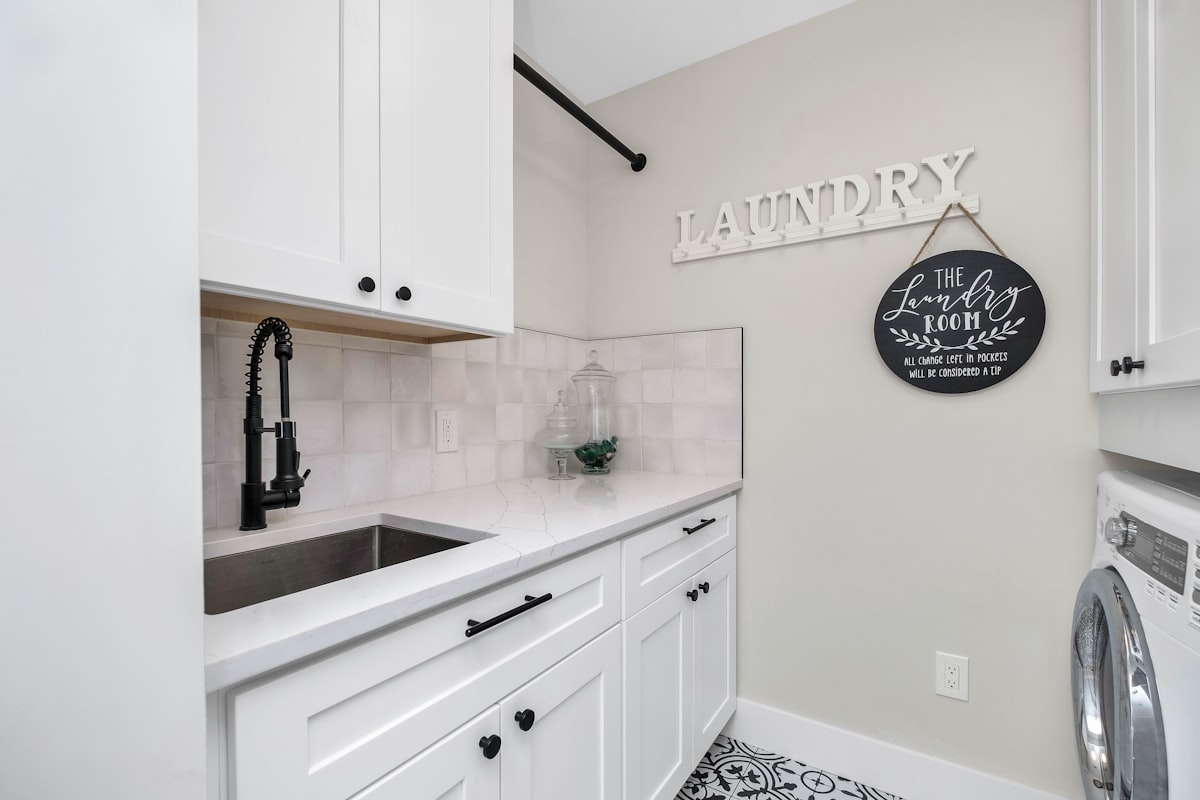 a laundry room with a sink and a washer and dryer related to Creating a Functional and Aesthetic Laundry Room Entryway