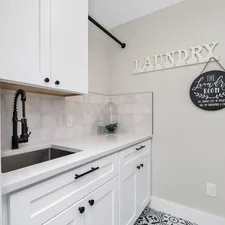 a laundry room with a sink and a washer and dryer related to Creating a Functional and Aesthetic Laundry Room Entryway