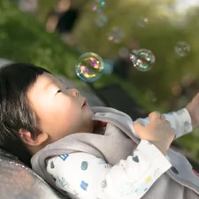 a little boy laying on top of a blanket next to bubbles related to Magical Dreams Await with a Toddler Bed Mickey Mouse
