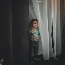 a little boy standing in front of a curtain related to Kids Curtain Valance: Elegant Window Treatments
