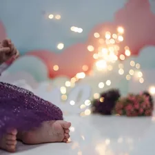 a little girl in a purple dress sitting on a table related to Magical Dreams Await with a Toddler Bed Mickey Mouse