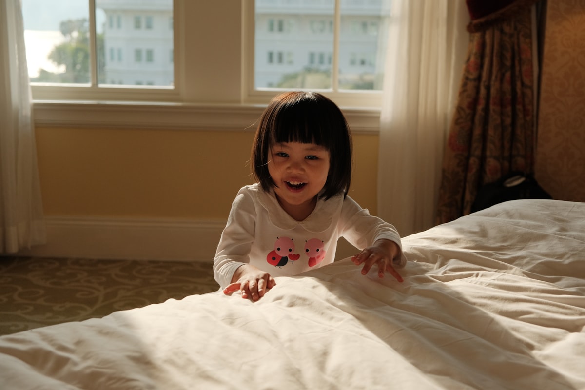 A little girl laying on a bed in a room related to The Enchanting World of Princess Toddler Beds