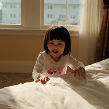 A little girl laying on a bed in a room related to The Enchanting World of Princess Toddler Beds