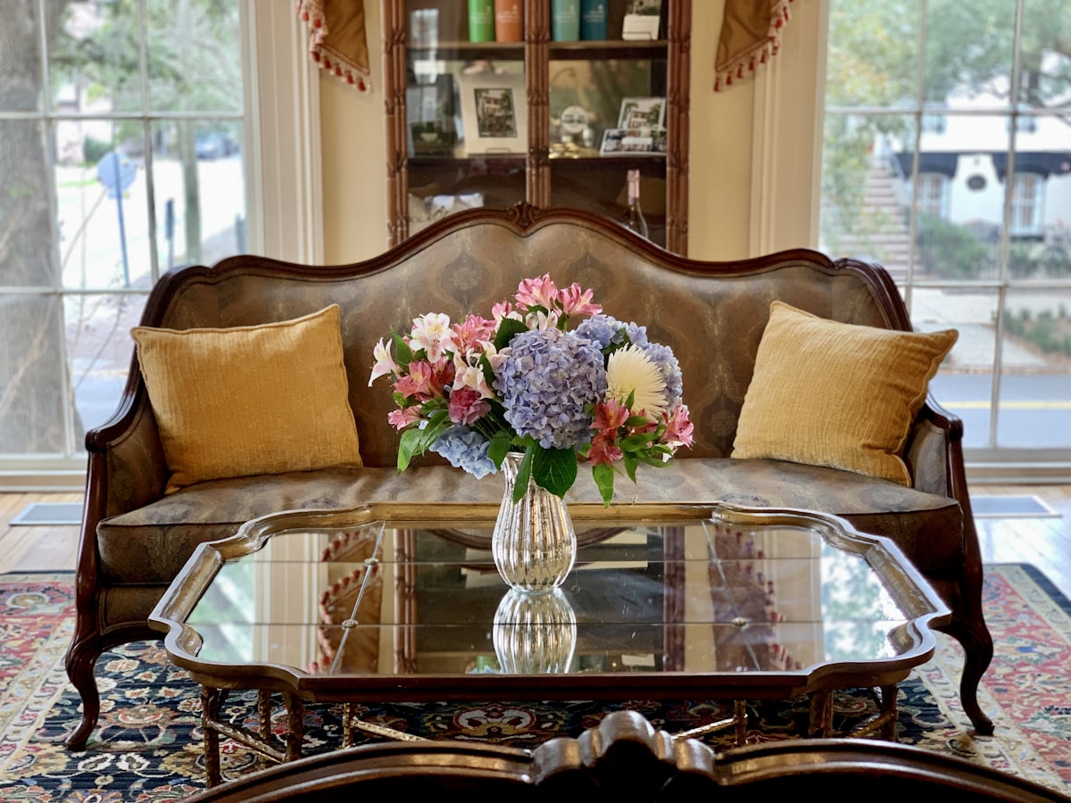 a living room with a couch and a table with flowers on it related to Elegant Touches: Exploring the Beauty of Cornice Valance Patterns