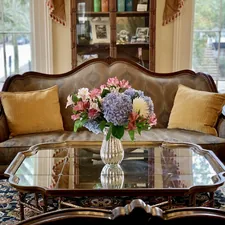 a living room with a couch and a table with flowers on it related to Elegant Touches: Exploring the Beauty of Cornice Valance Patterns