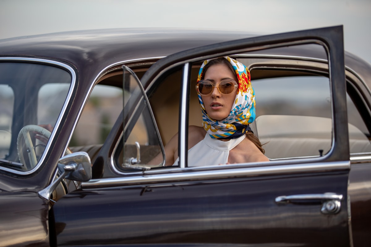 A look from the 1950's, a woman looks out of her vintage german auto. related to Elegant Touches: Scarf Window Valance Ideas