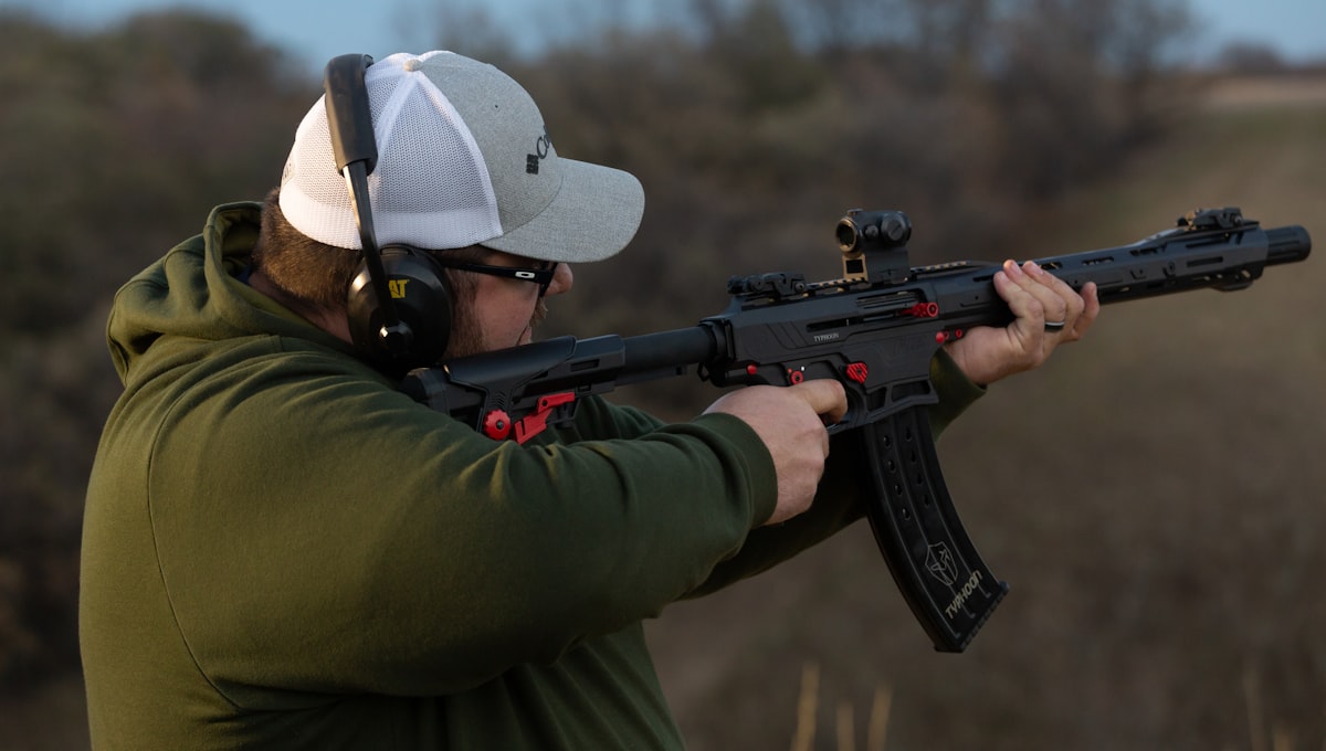 a man holding a rifle and wearing a hat related to Maximizing Your F250 Short Bed: A Complete Guide
