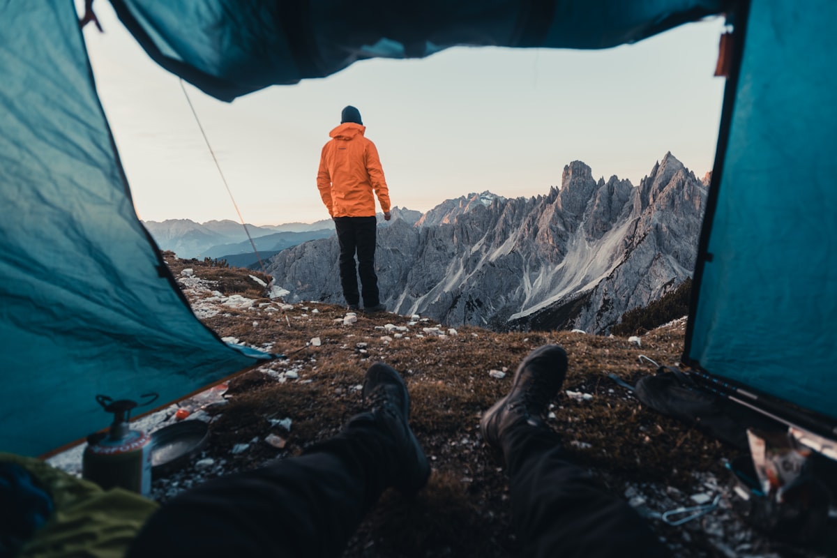 a man in an orange jacket standing in front of a tent related to Revolutionizing Your Outdoors: Outdoor Sideboards and Buffets