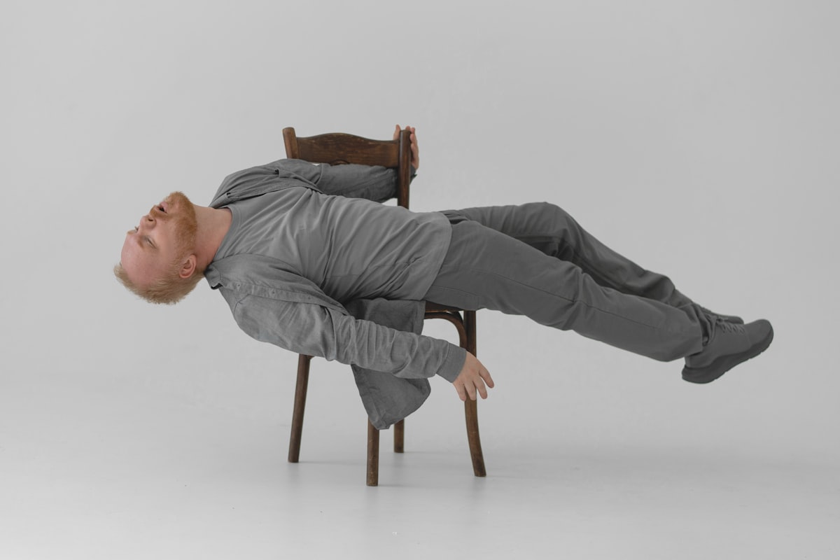 a man laying on a chair in the middle of the floor related to Space-Saving Marvels: The Ultimate Chair That Doubles as a Bed