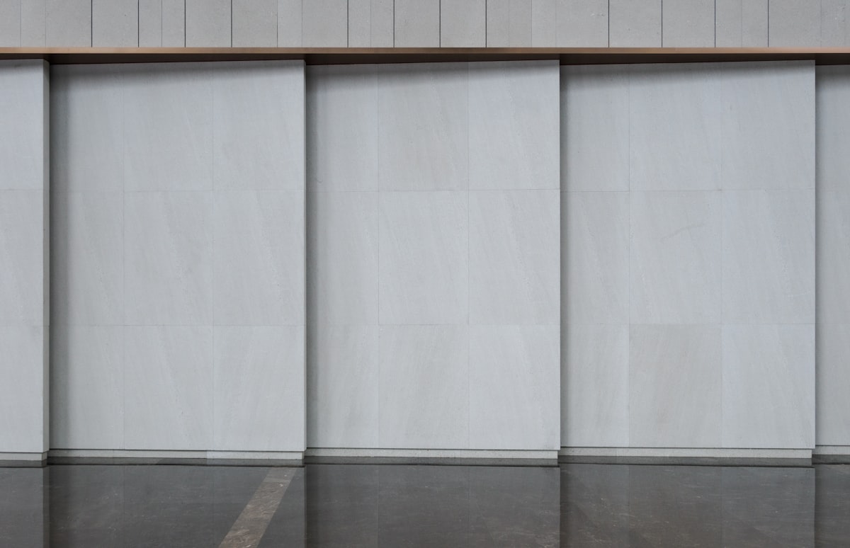 A man walking down a street past a tall building related to Sliding Glass Door Valance Ideas